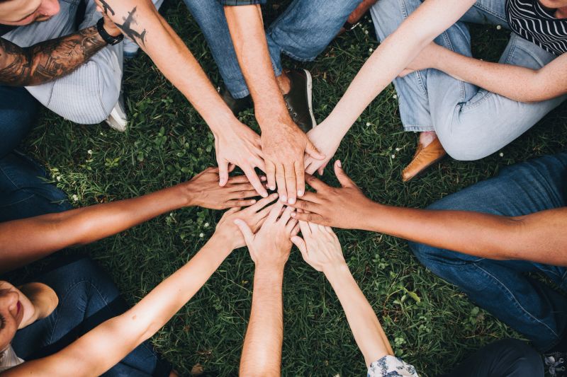 Community members joining hands together
